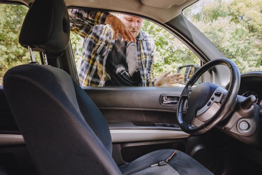 Man trying to retrieve keys that are locked inside his vehicle