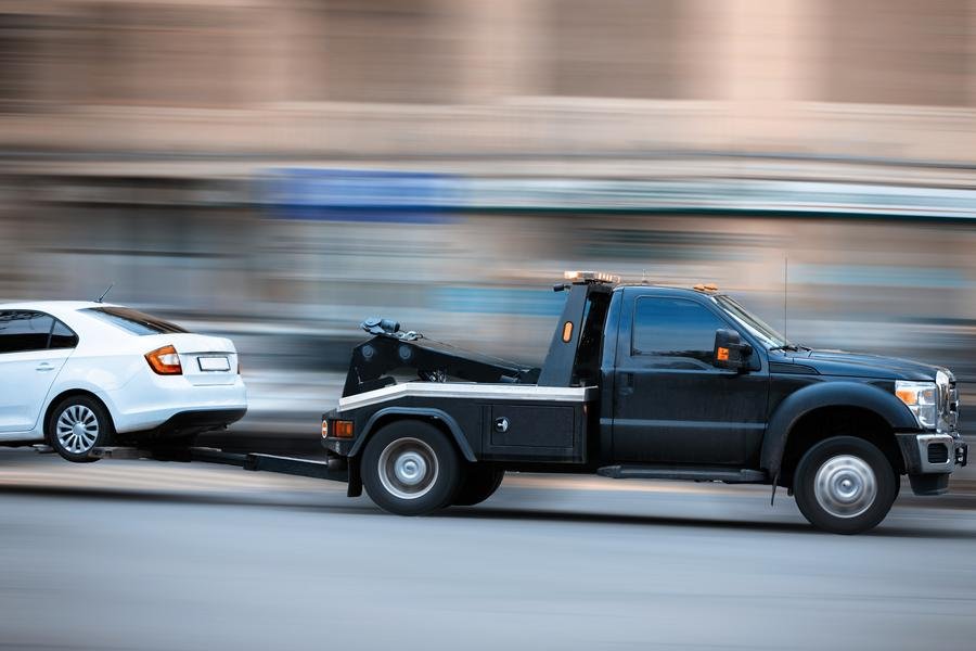 Tow wrecker truck towing a car in Newmarket